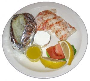Poor mans lobster, baked potato and lemon dinner plate.