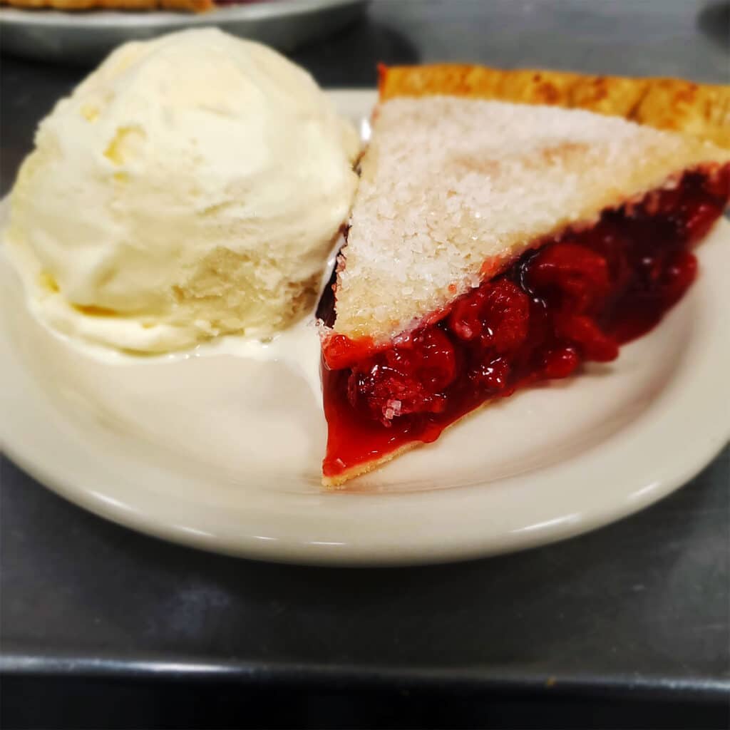 Cherry pie dessert with vanilla ice cream.